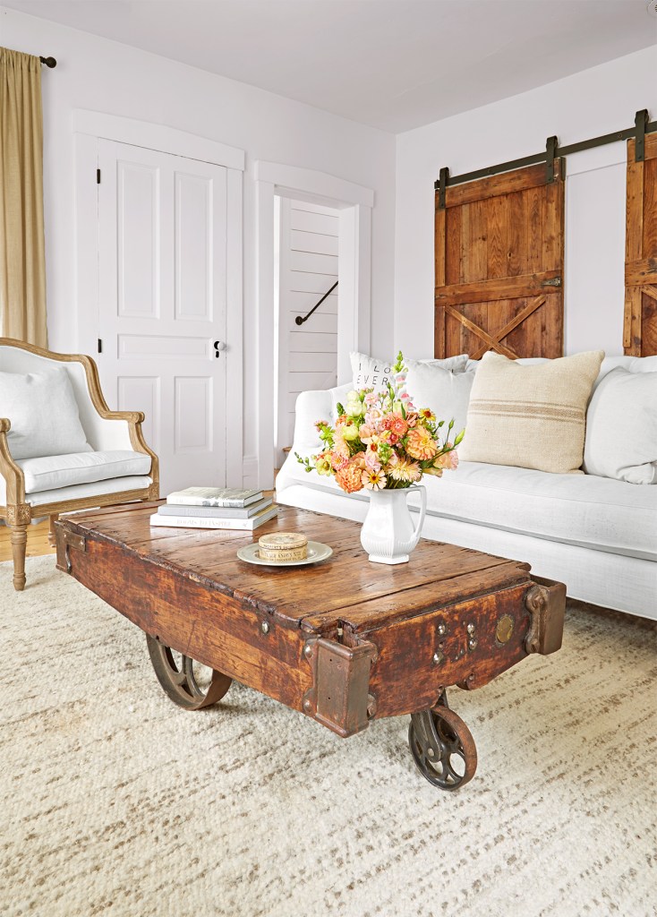 Sala com sofá com branco, poltrona e mesa de centro vintage