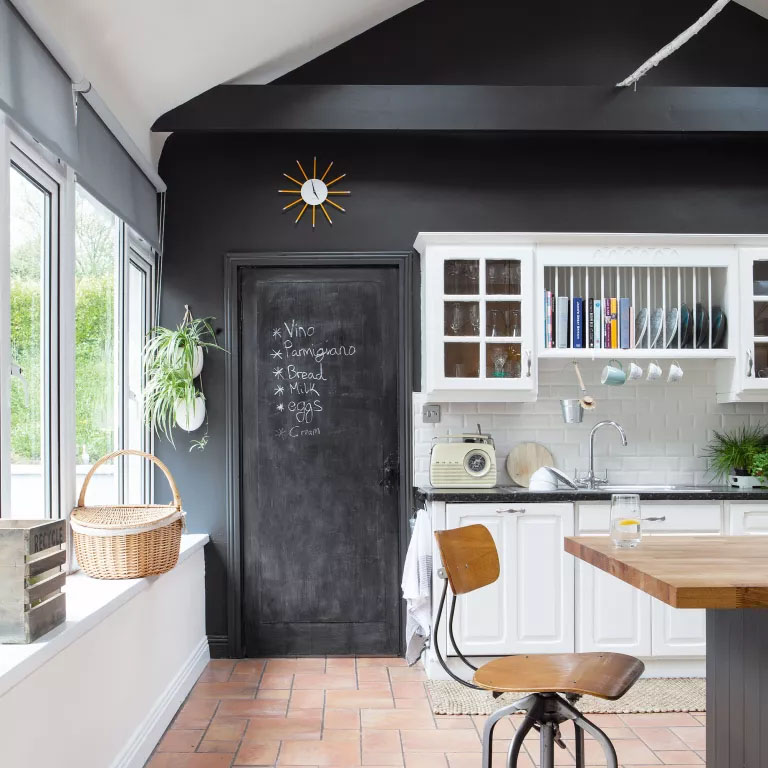 Cozinha com uma porta com quadro negro.