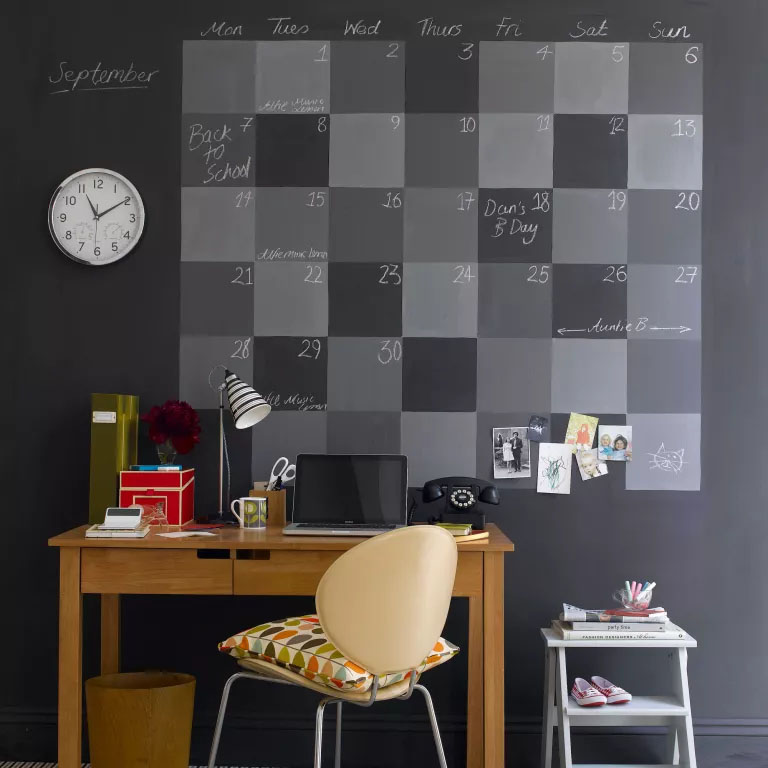 Escritório com um grande quadro negro ilustrando um calendário mensal.