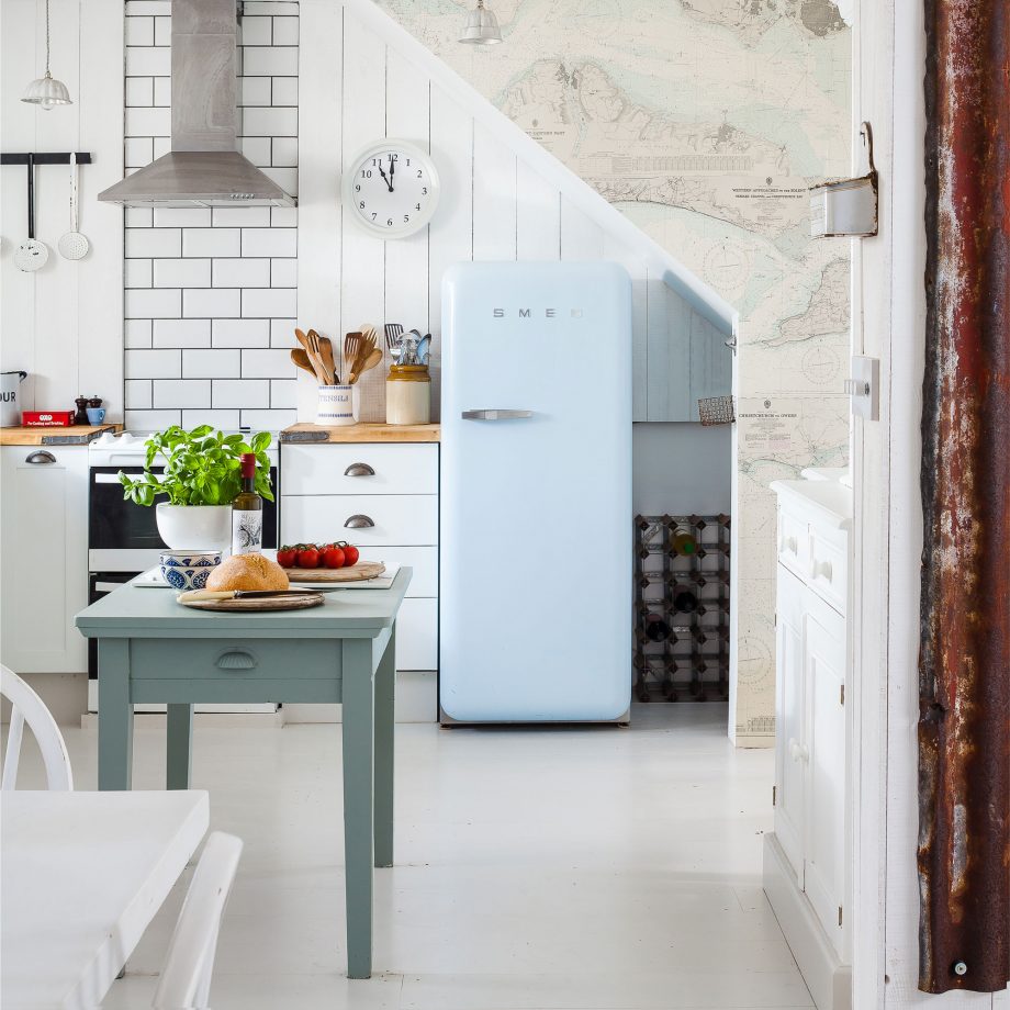 Cozinha retrô com subway tiles; geladeira azul; mesa pequena