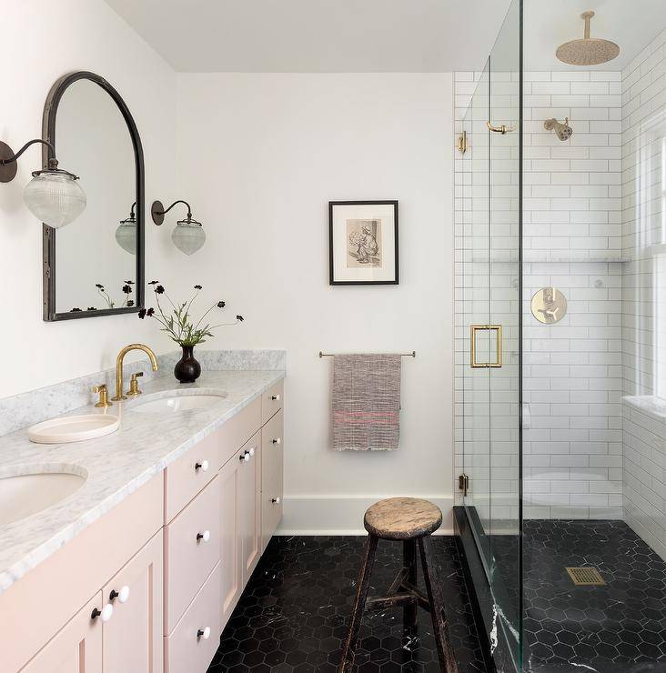 Banheiro com chão preto e armários rosa.
