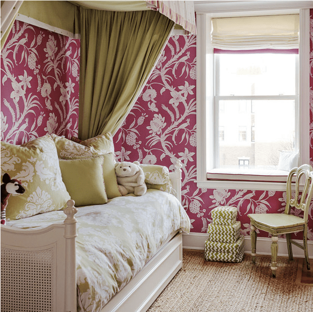 Quarto com papel de parede com rosas, um sofá-cama e uma cortina verde azeitona