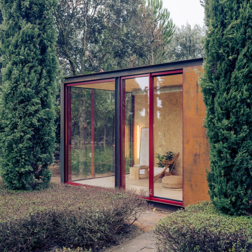 Estúdio em jardim tem estrutura metálica e quase todas as paredes com fechamento em vidro que permitem contato com a natureza.