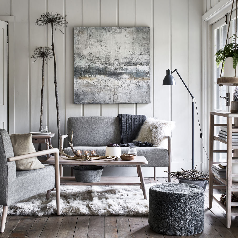Sala de estar em estilo escandinavo com sofás e poltronas em estrutura de madeira finos.