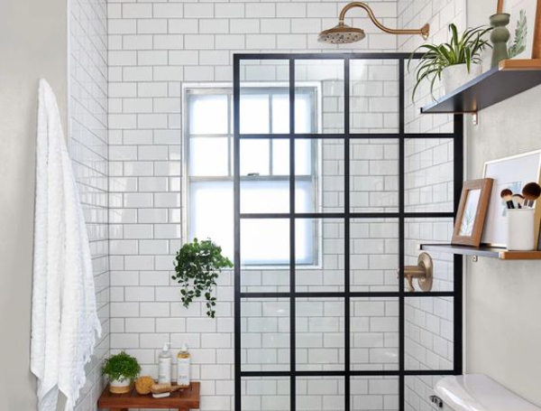 Banheiro pequeno com box de vidro e ferragens pretas e azulejos brancos