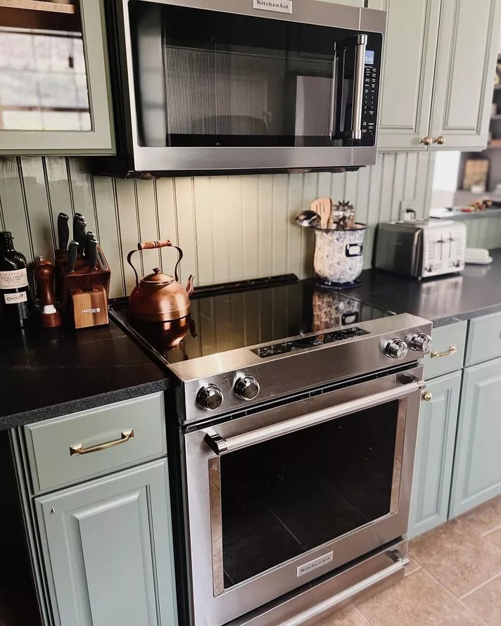 Cozinha com backsplash em painel de madeira verde.