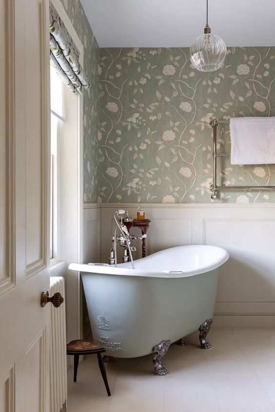 Banheiro em cores clara com banheira vintage de pés de garra.