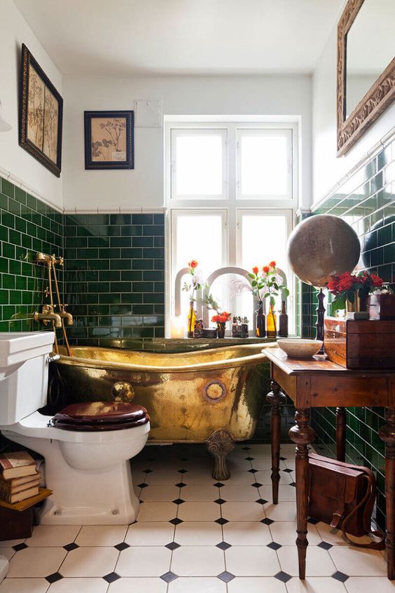 Banheiro com banheira vintage dourada.