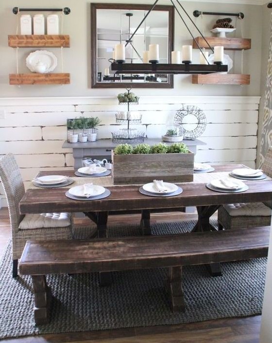 Sala de jantar com mesa e bancos de madeira escura.