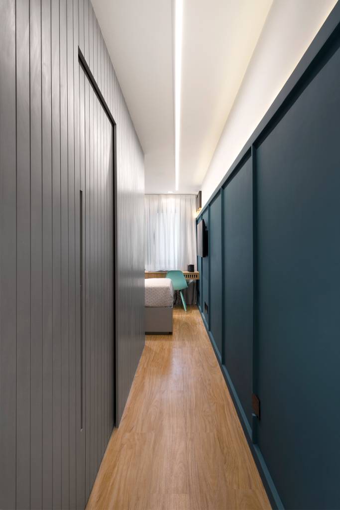 Corredor com parede de painel cinza e boiserie azul