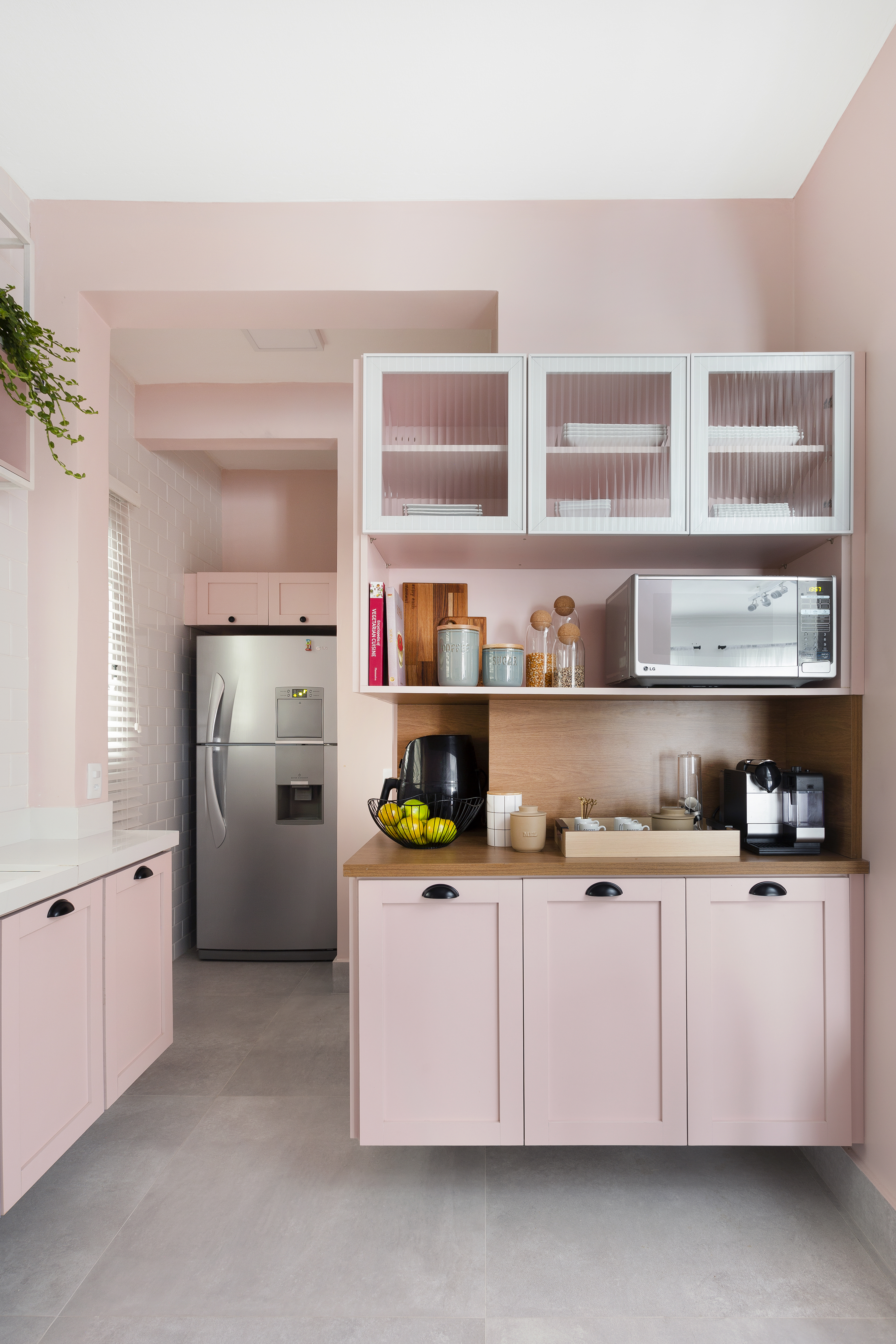 Delicado: cozinha com marcenaria rosa é destaque neste apê