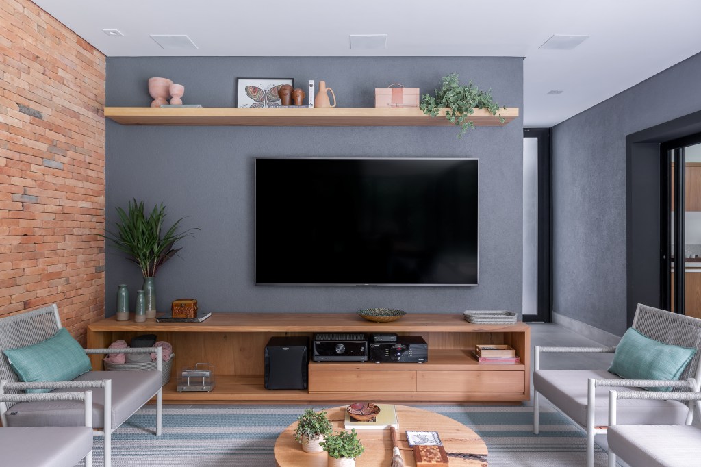 Sala de tv com painel cinza
