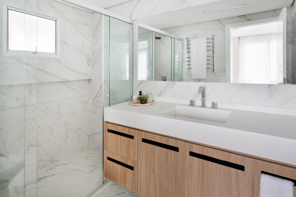 Banheiro com revestimento de mármore no piso e parede