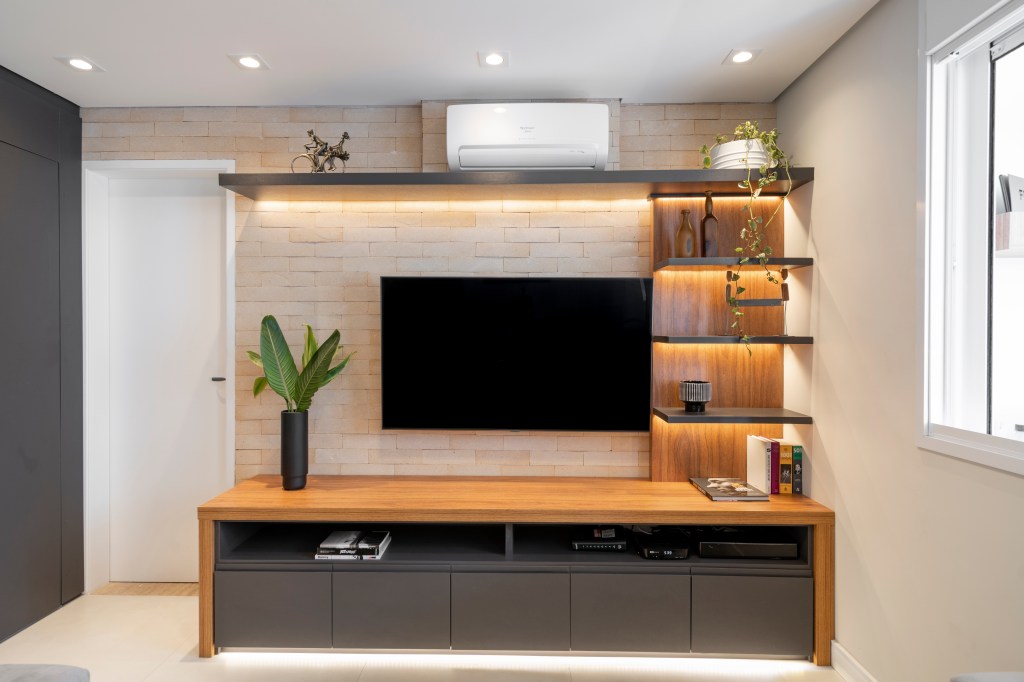 Área de TV com tijolinhos e estantes com LED