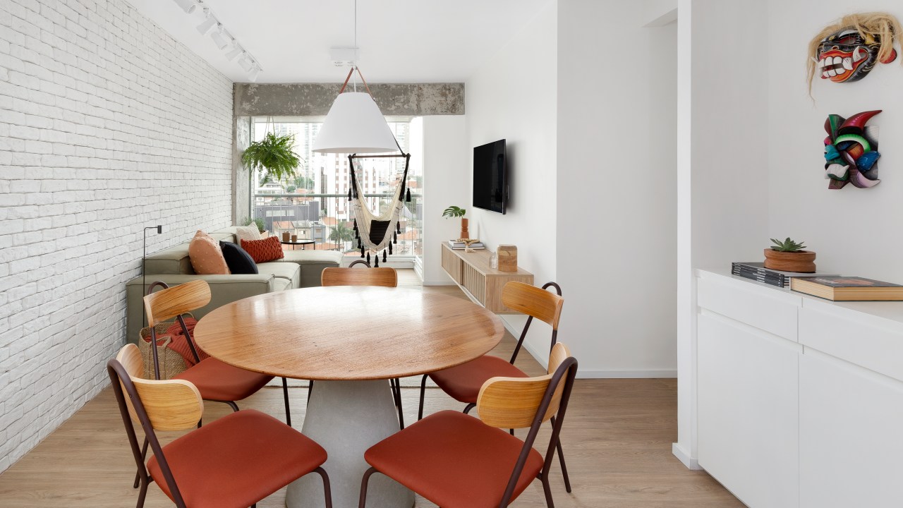Sala de estar integrada com jantar; mesa redonda de quatro lugares; luminária