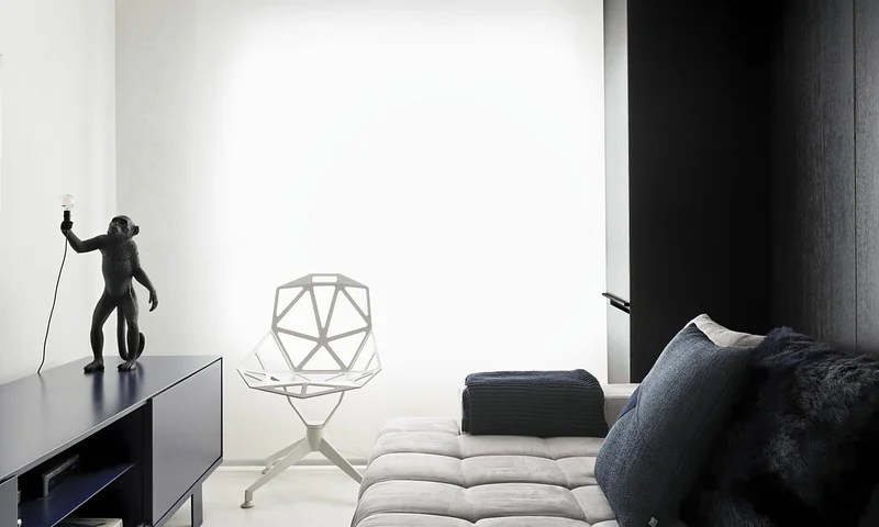 Quarto minimalista com cama e rack preto