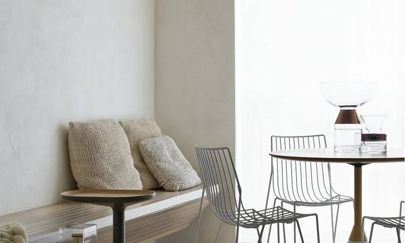 Sala minimalista com banco e mesa de jantar redonda