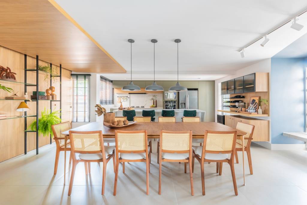 Sala de jantar integrada com mesa e cadeiras em madeira;