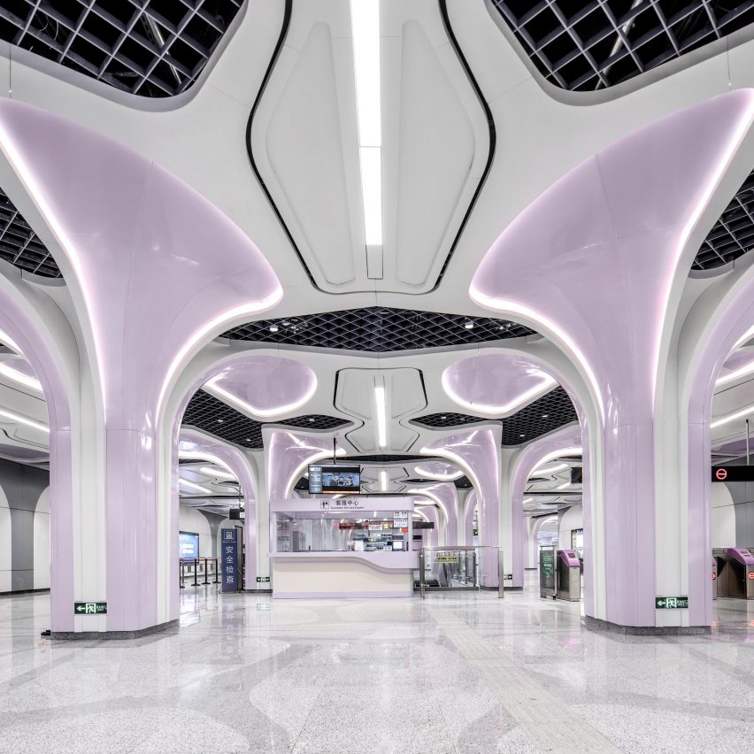 Estação de metrô na China com estrutura metálica em tom de lilás e colunas que remetem à cenário futurista.