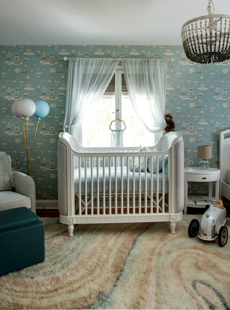 Quarto de bebê azul com berço branco em frente à janela