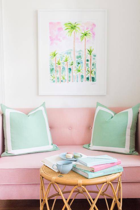 Sala de estar com sofá rosa pastel e mesa de centro de vime