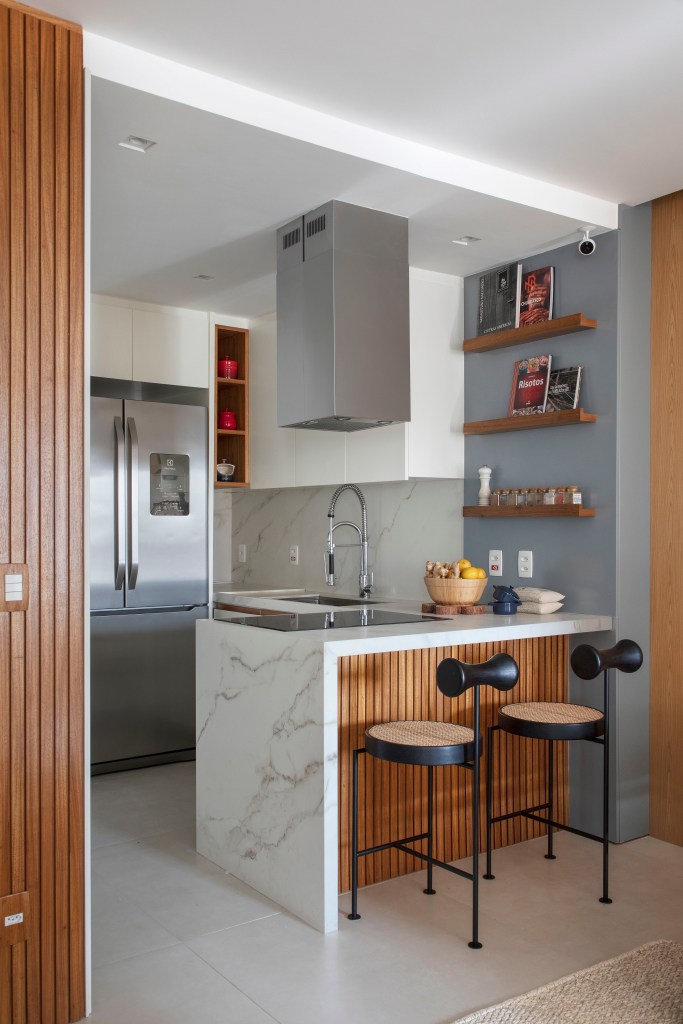 Cozinha com bancada de pedra e madeira integrada à sala de estar