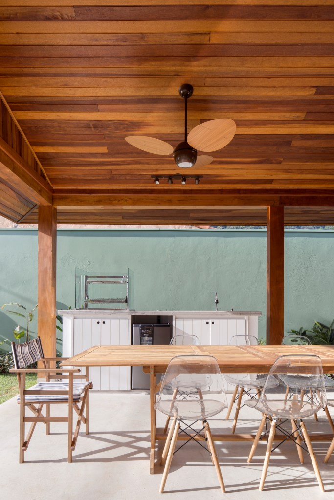 Casa-na-praia-de-140-m2-se-torna-mais-ampla-com-paredes-de-vidro-projeto-anga-arquitetura-foto-Carolina-Lacaz-area-externa-churrasqueira Área gourmet com mesa de jantar