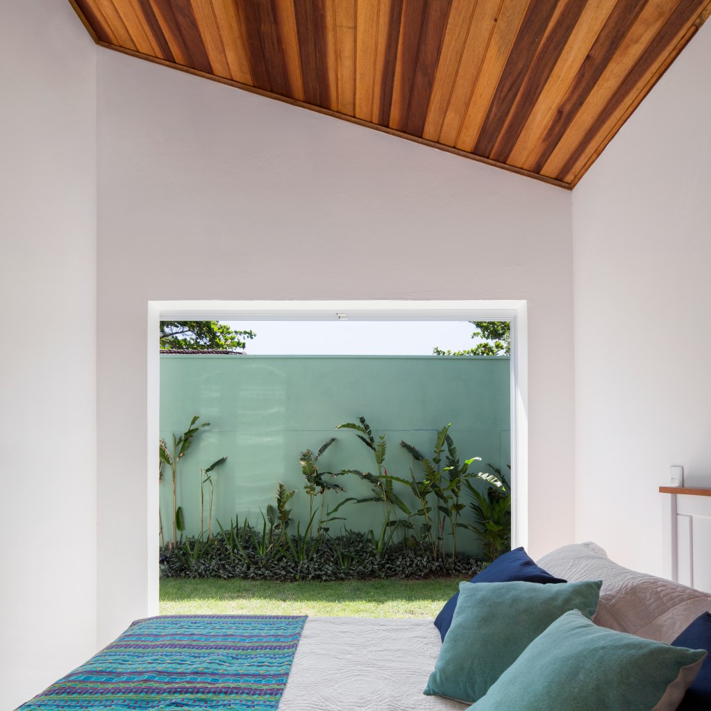 Casa-na-praia-de-140-m2-se-torna-mais-ampla-com-paredes-de-vidro-projeto-anga-arquitetura-foto-Carolina-Lacaz-parede-vidro-quarto Quarto com janela grande