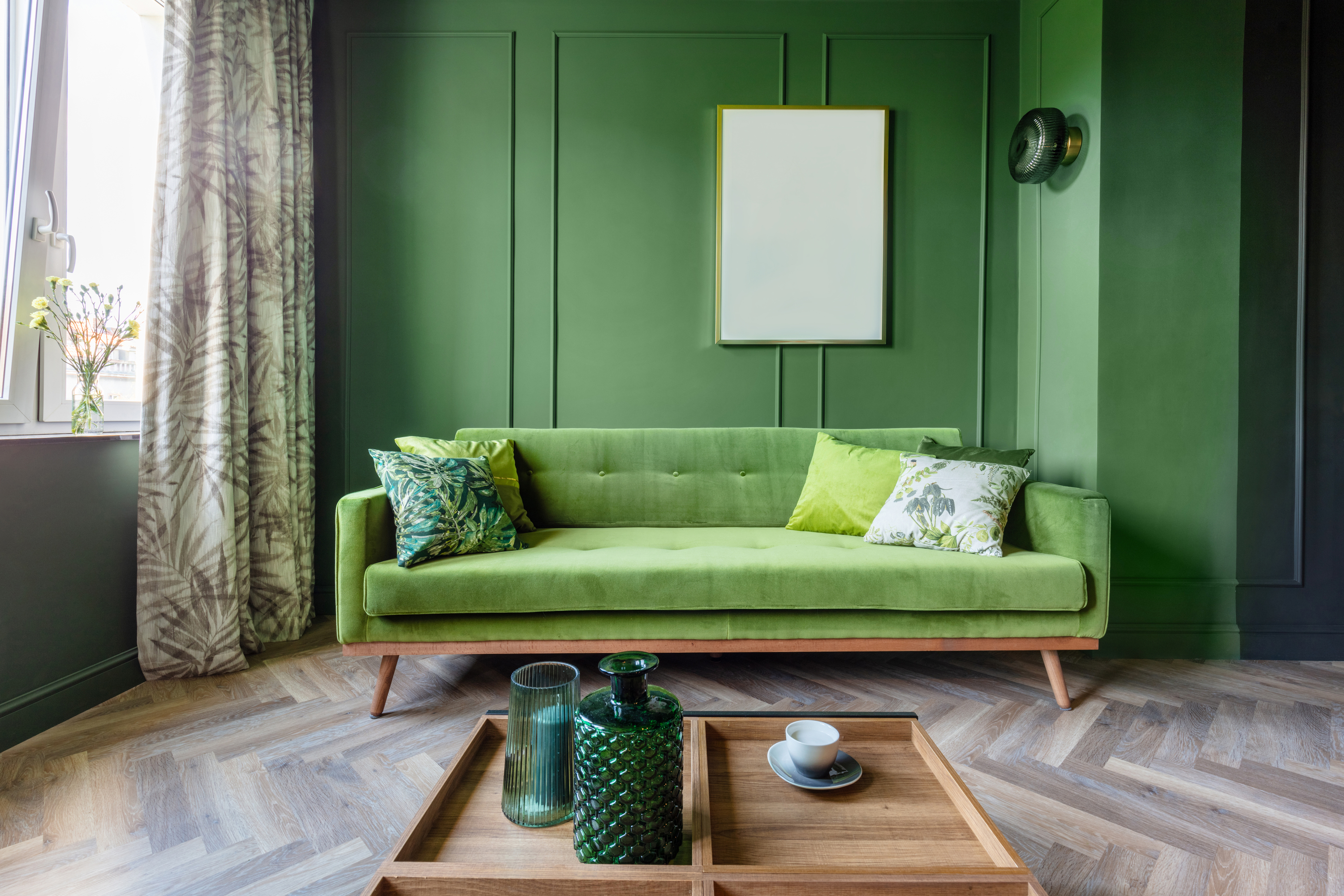 Sala de estar com parede, sofá e acessórios em verde