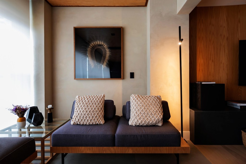 Sala de estar com duas poltronas sem braços iluminada por luz quente suave.