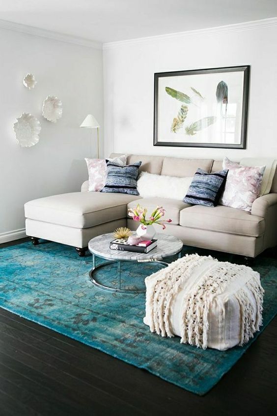 Sala de estar pequena 40 inspirações com estilo DigsDigs (3) Sala de estar pequena com sofá em L, decorada em tons neutros. Um tapete azul turquesa é o destaque do ambiente.