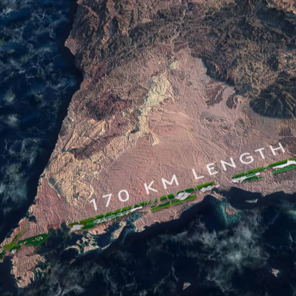 Prédios em forma de muralhas correm paralelos por 170 km em região desértica até a costa de um mar azul.