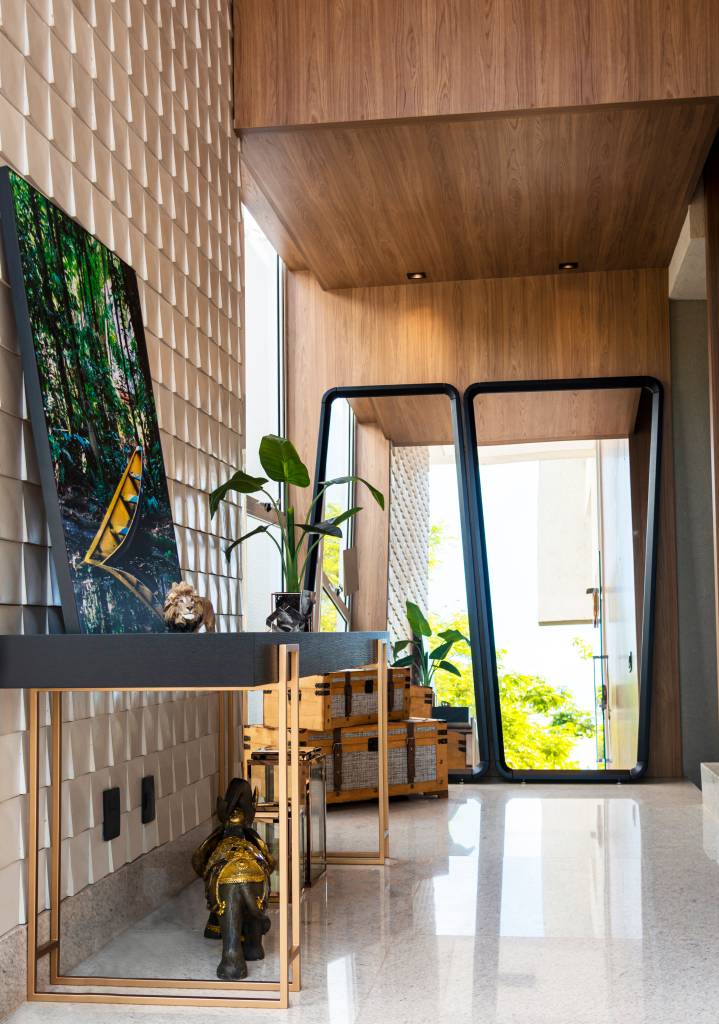 Sala com parede vazada; aparador preto com base metáliza