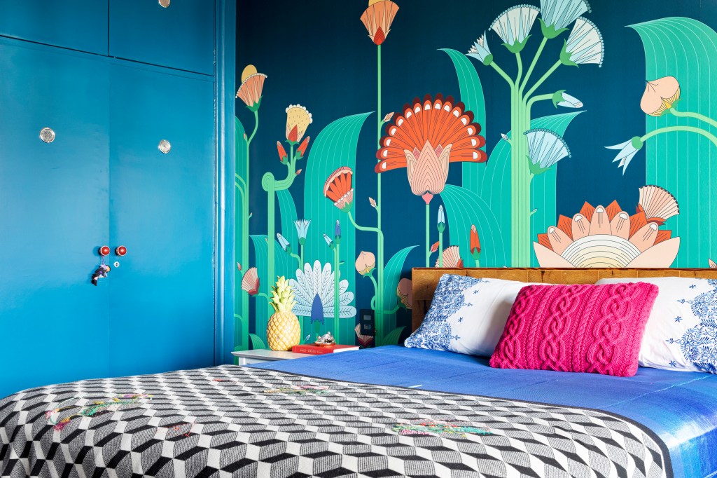 Quarto com cama e paredes com desenhos florais
