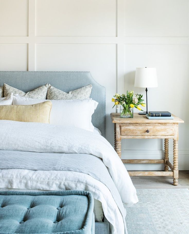 quarto-cama-cabeceira-mesa-lateral-azul-abajur-mydomaine Quarto com roupas de cama azuis; mesinha lateral; cabeceira estofada e boiseries