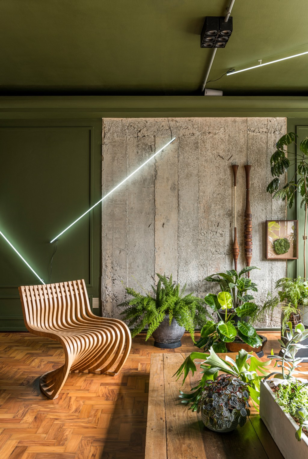 Sala de estar em cinza e verde e poltrona de madeira