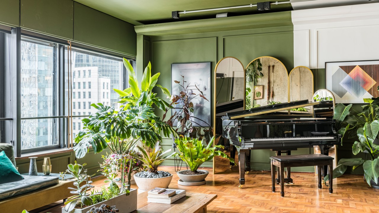 Sala de estar com plantas, piano e itens de design