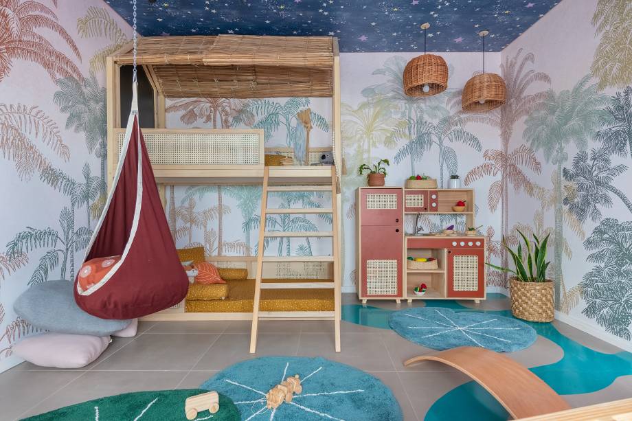 Floresta Encantada, por Stephanie Ribeiro e Baby Abdalla. Com 19,38 m², o quarto com brinquedoteca foi inspirado no desenho Peter Pan, da Disney. A ideia das arquitetas foi criar um ambiente lúdico de aventura e fantasia onde a criança pode se divertir e brincar. A criação de elementos simples que podem instigar a imaginação, como o adesivo no piso e o teto estrelado, ganham destaque junto a Beliche Casa na Árvore, lançamento da Muskinha e papel de parede desenvolvido em parceria com a Manual Design especialmente para o ambiente.