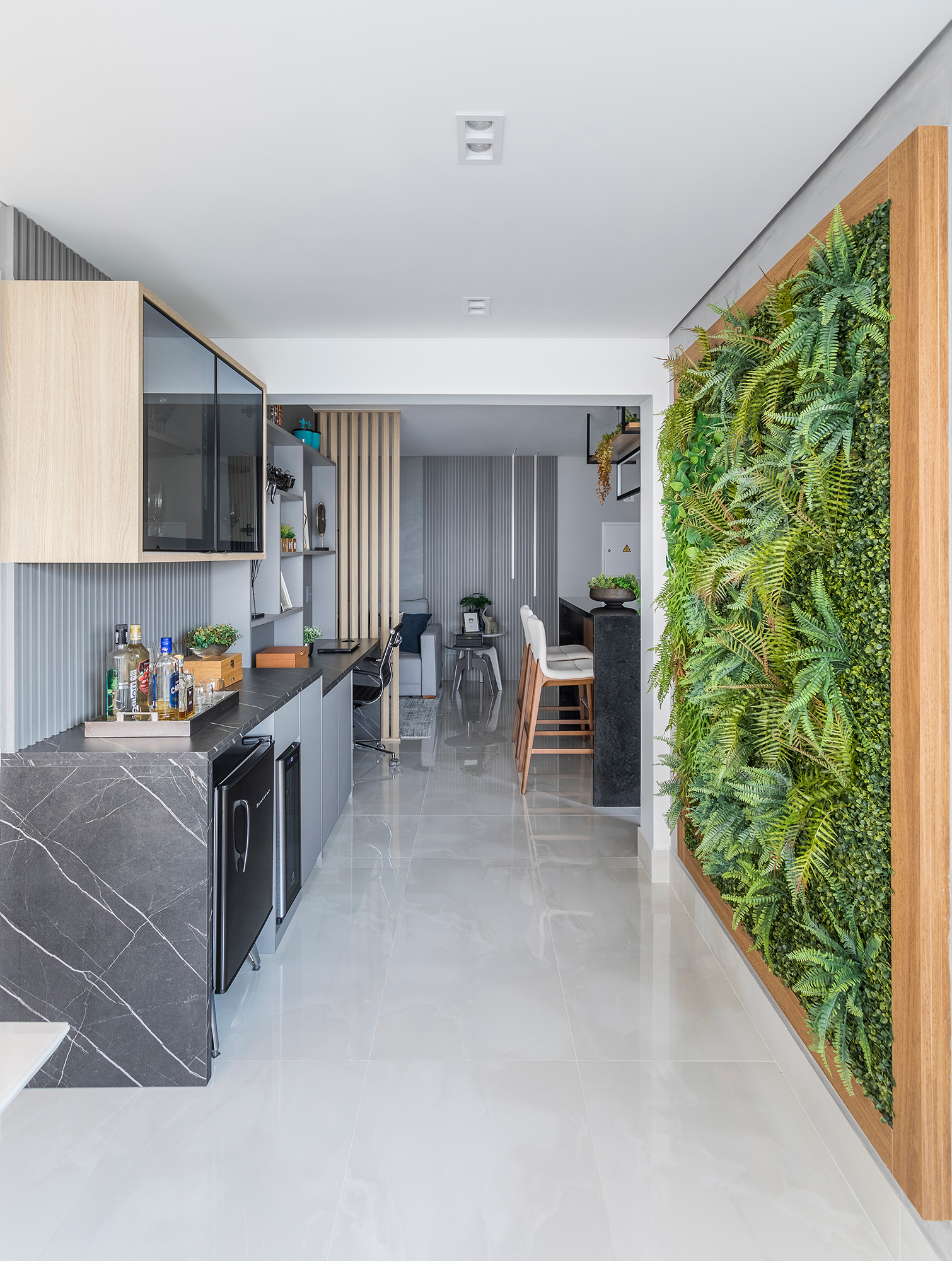 Apartamento de 82 m² ganha jardim vertical no corredor e cozinha com ilha