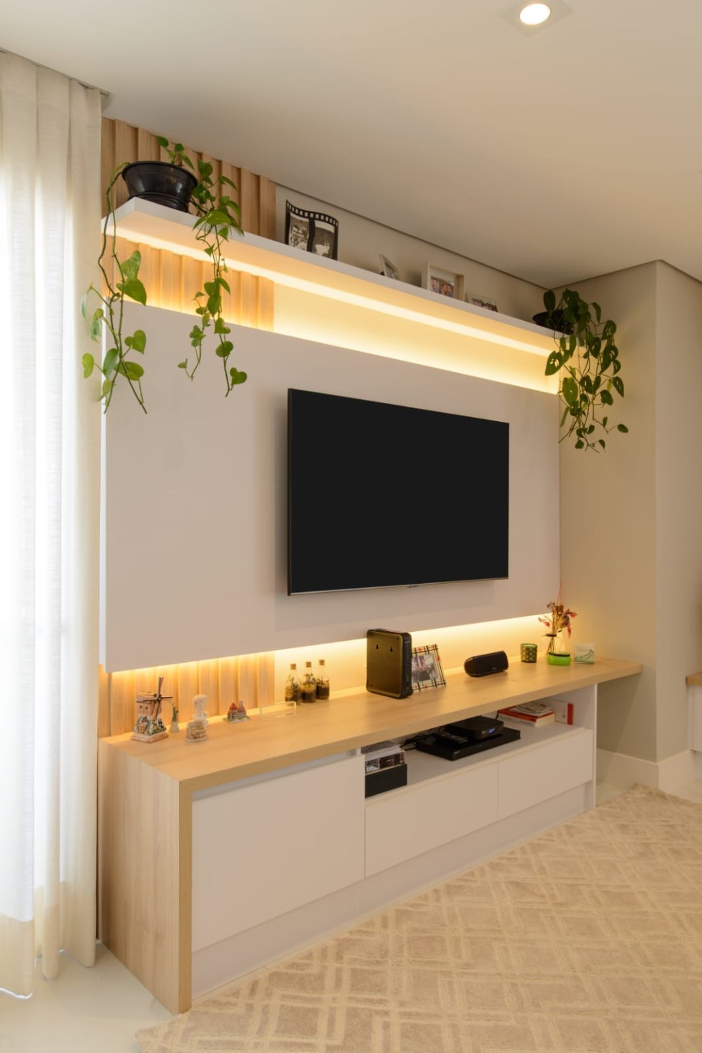 Sala de tv com painel branco e prateleiras