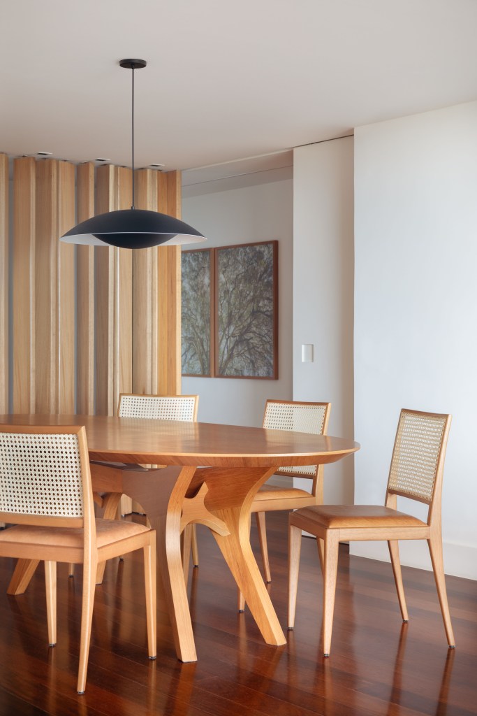 Sala de jantar com mesa e cadeiras em madeira