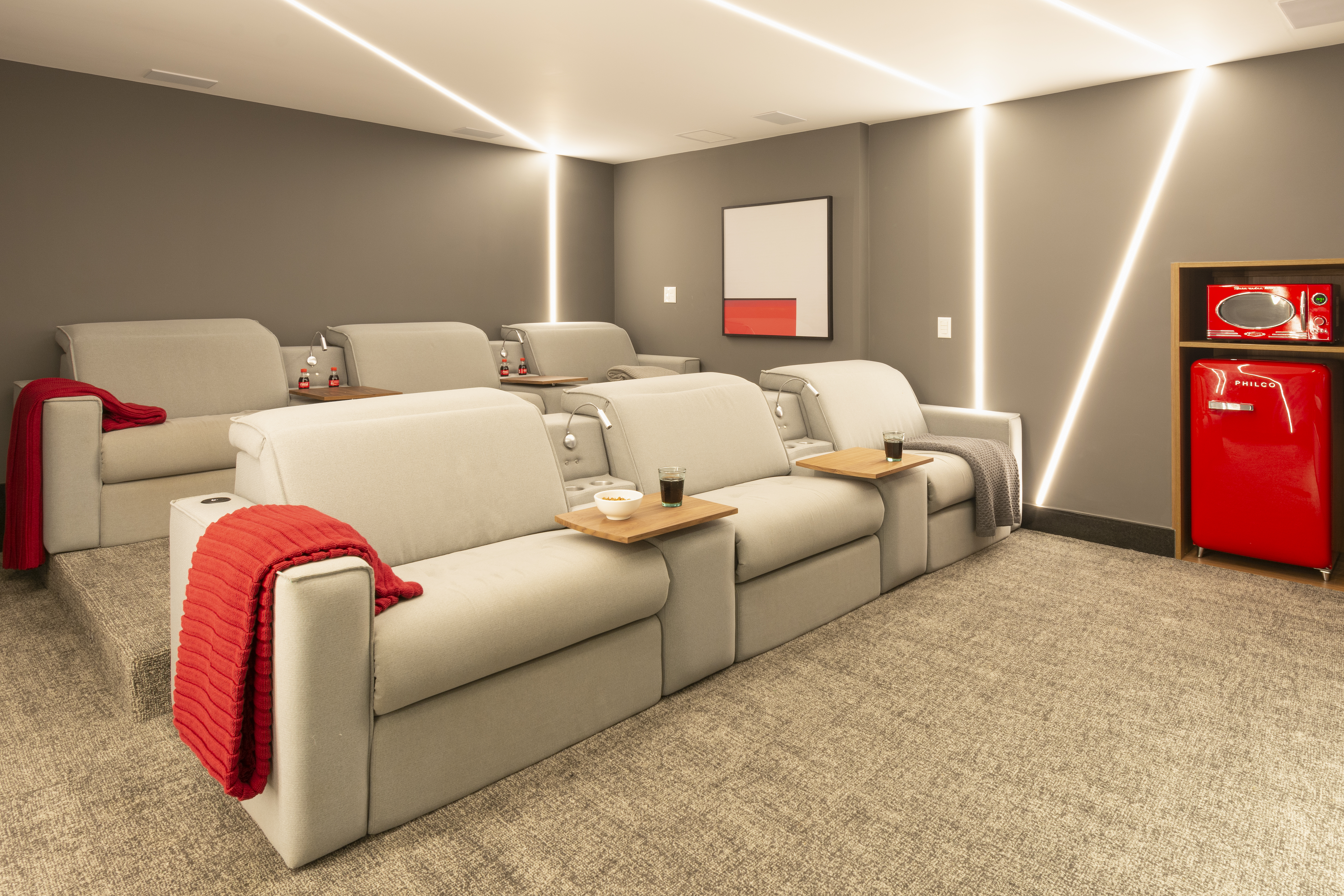Sala de cinema com pipoqueira e poltronas é destaque em casa de 400m²
