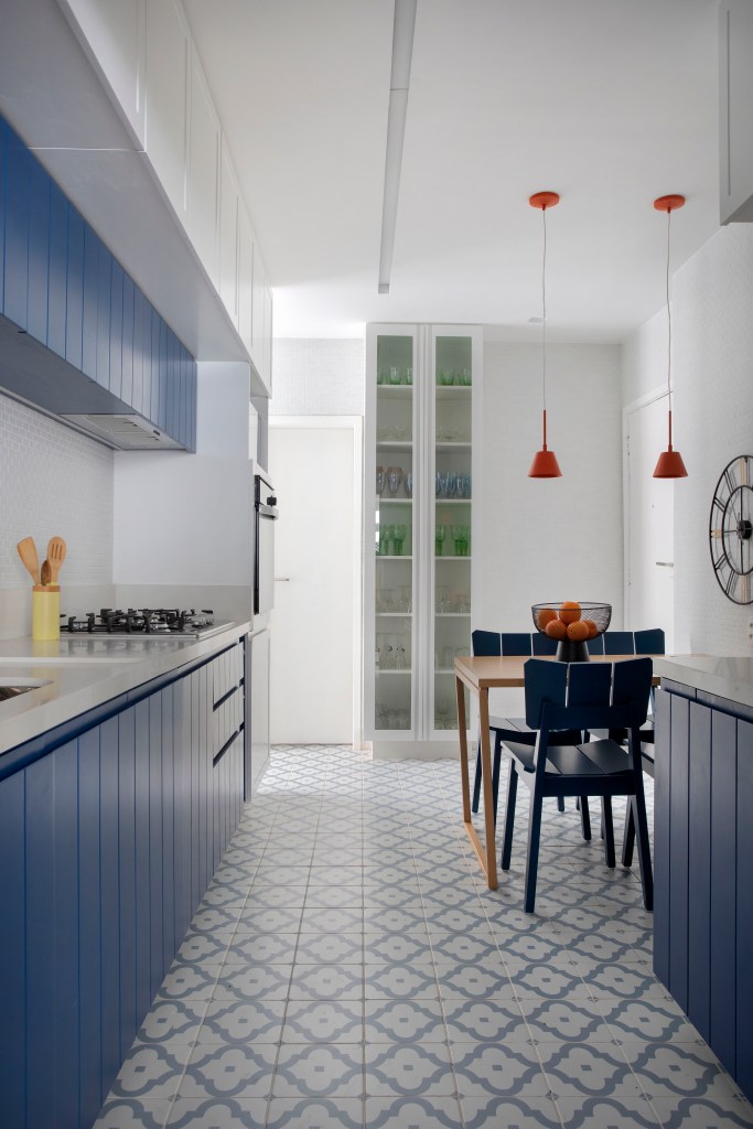 Cozinha com marcenaria azul e piso em ladrilhos