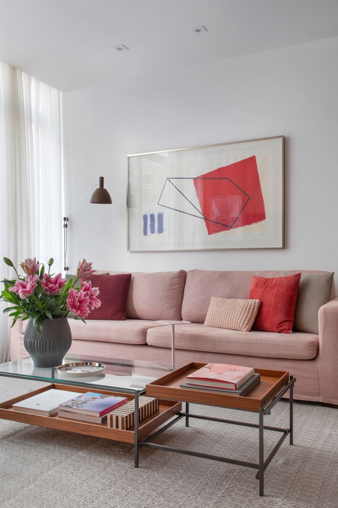 Sala de estar com sofá rosa e mesa de centro