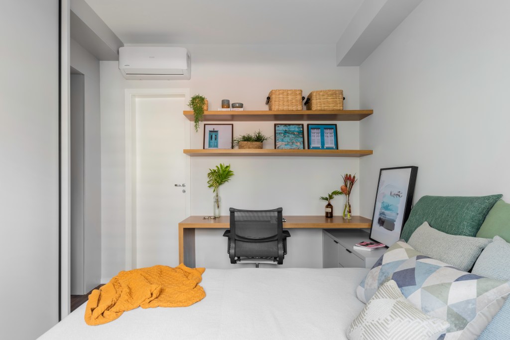 Quarto com cama e espaço para home office