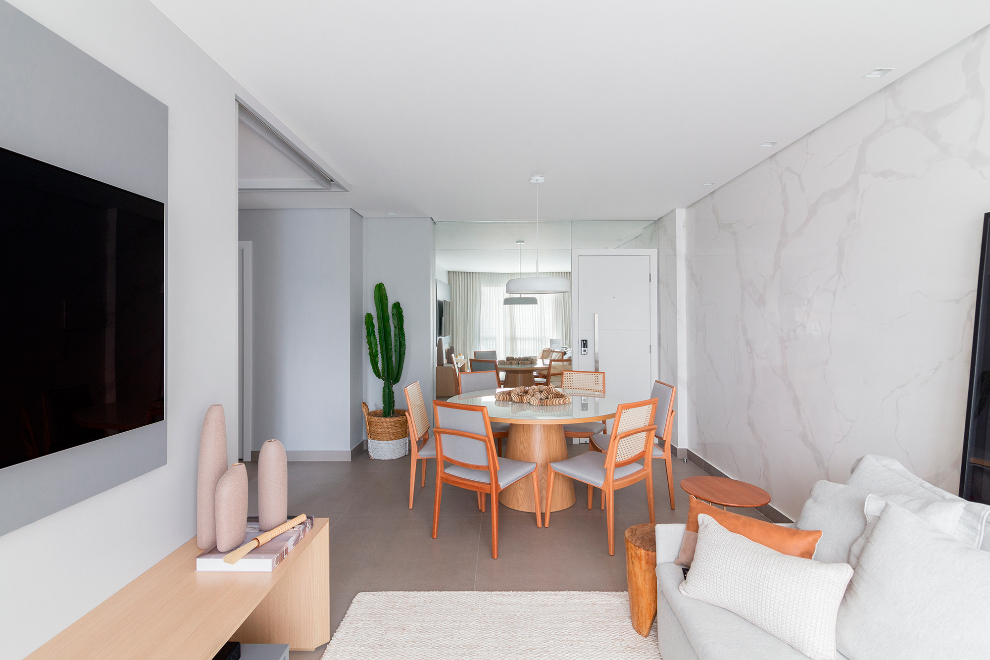 Luz natural e decoração minimalista promovem aconchego em apê de 97 m²