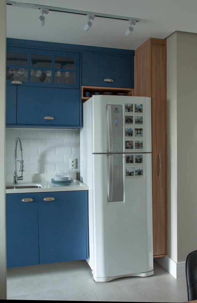 Cozinha com marcenaria azul e geladeira