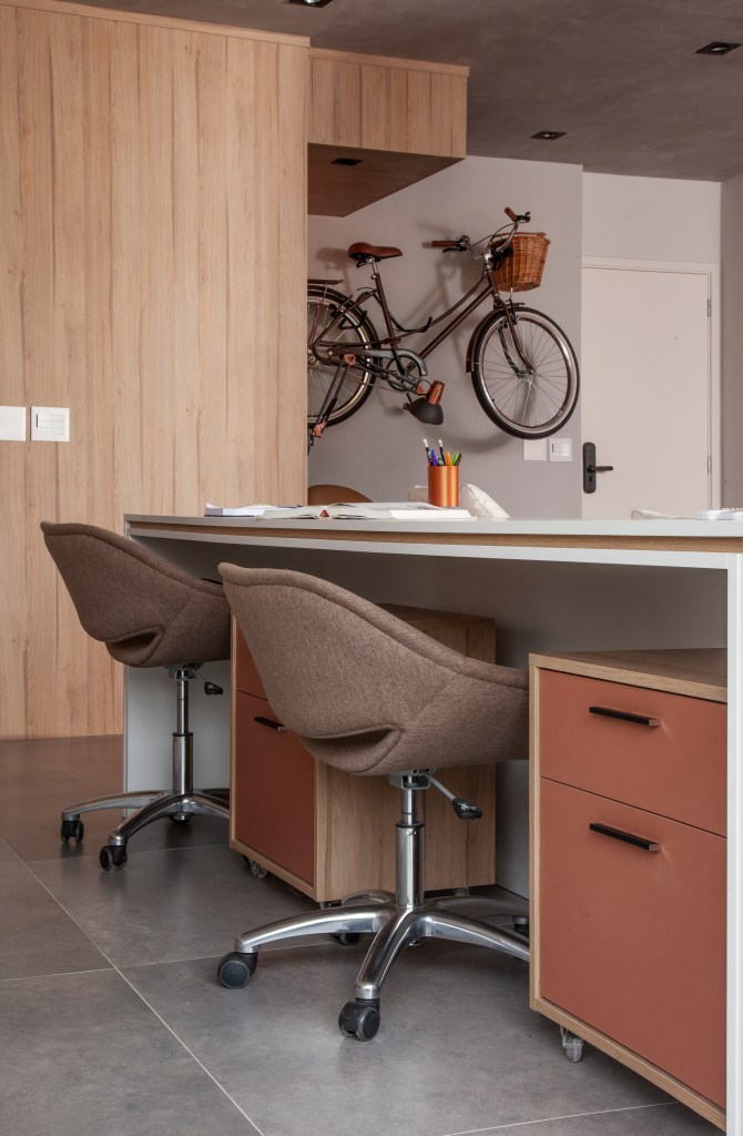Home office com duas cadeiras e armário móvel acoplado embaixo da bancada
