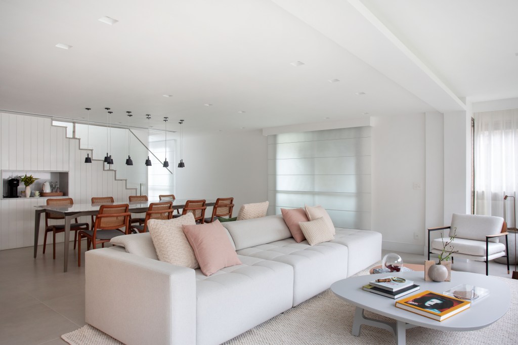 Sala de estar integrada com jantar; sofá branco; tapete branco; sala branca
