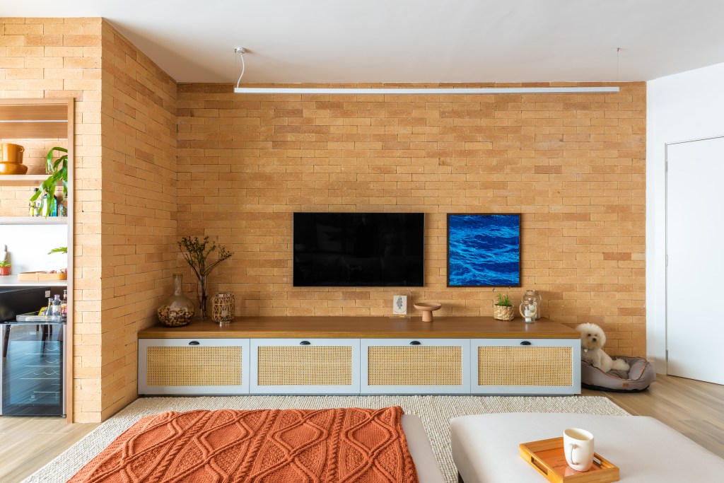 Sala de tv com parede em tijolinhos